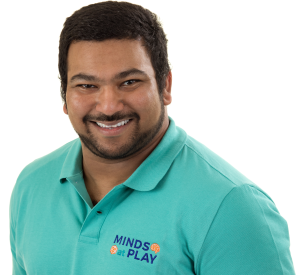 Dwayne Fernandes smiling at camera. His polo shirt has the Minds At Play logo on it.